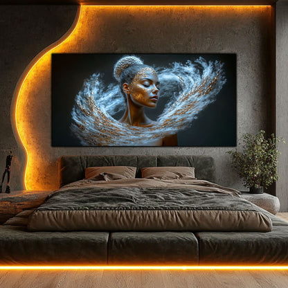 Tablou decorativ modern pe sticlă securizată – portret feminin eterat în vârtej de particule albe-argintii și aurii, colecția Celestial Embrace, montat într-un dormitor de lux cu iluminat ambiental auriu și perete de beton texturat.